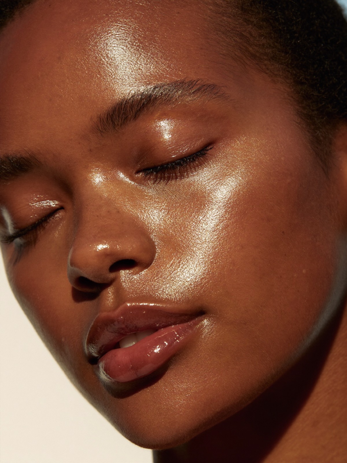 Close-up of radiant, luminous glass skin with a serene expression